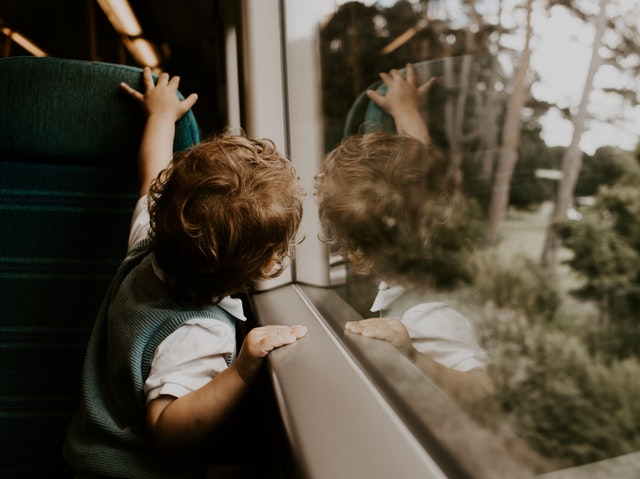 Malý chlapec pozerá z okna